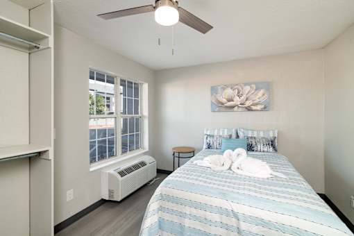 a bedroom with a large bed and a ceiling fan