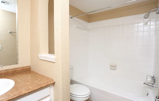 A bathroom with a toilet, sink, and bathtub.