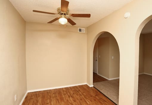 A room with a ceiling fan and a carpeted floor.