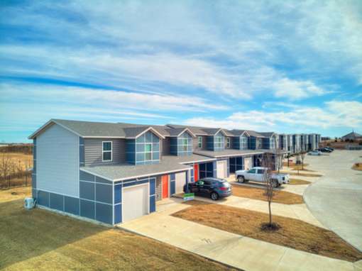 a row of houses with cars parked in front of them