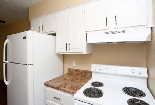 A white refrigerator and stove in a kitchen.