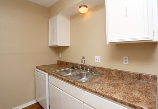 A kitchen with a granite countertop and white cabinets.