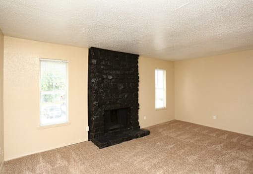 A room with a fireplace and carpeting.