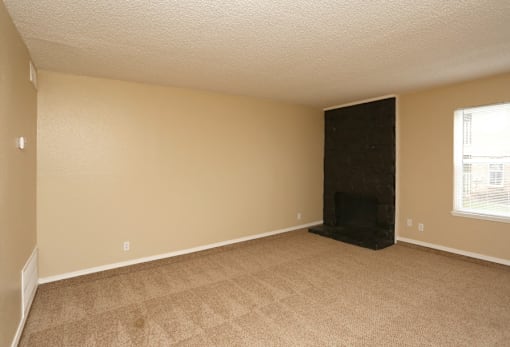 A room with a fireplace and carpeted floor.