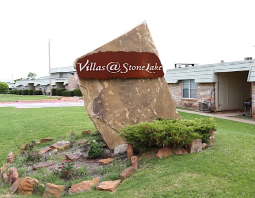 A large rock with the text "Villas @ Stone Lake" carved into it.