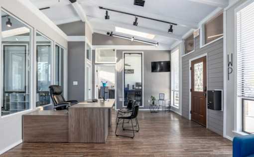 A modern office space with a wooden desk and a black chair.