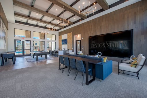 a large conference room with a large table and chairs and a pool table in front of a at Alta Denton Station, Denton, Texas