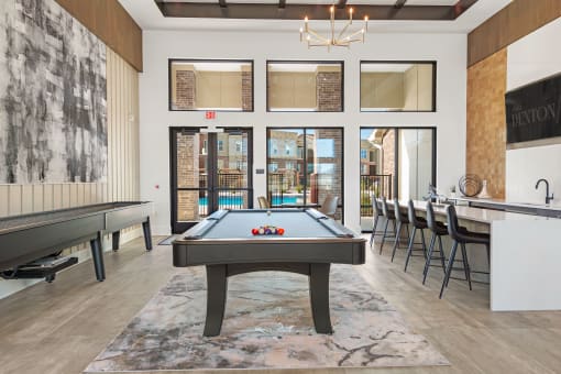 a pool table and bar in the resident lounge at Alta Denton Station, Denton, Texas