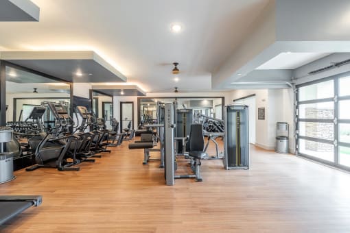 Fitness Room with Cardio Machines and a Wood Floor at AVILA Apartments, Florida