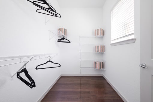 White Closet with Black Hangers on the Wall and a Window at AVILA Apartments, Oviedo, 32765