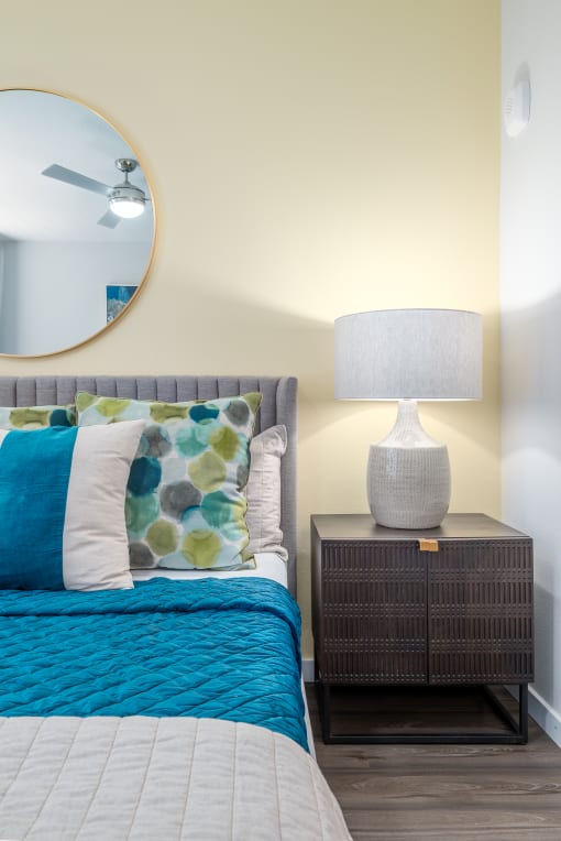 a bedroom with a bed and a nightstand with a lamp at Alta at Horizon West, Winter Garden