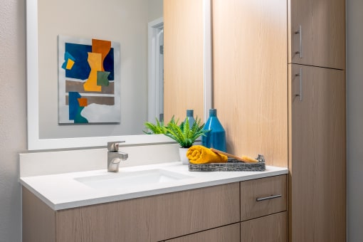 a bathroom with wood cabinets and a white sink at Alta at Horizon West, Winter Garden