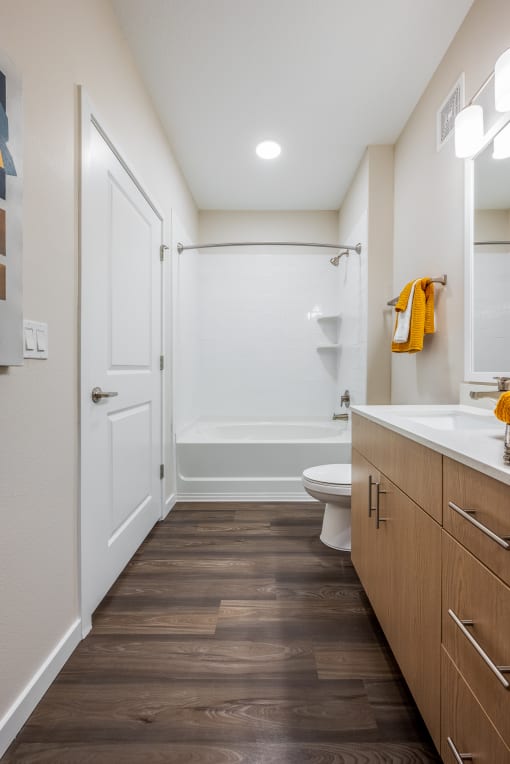 a bathroom with a toilet sink and bathtub in a 555 waverly unit at Alta at Horizon West, Winter Garden