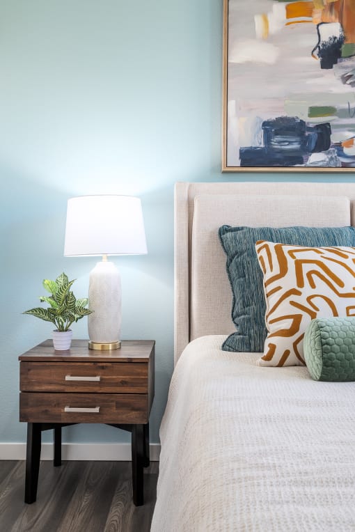 a bedroom with a bed and a nightstand with a lamp on it at Alta at Horizon West, Winter Garden