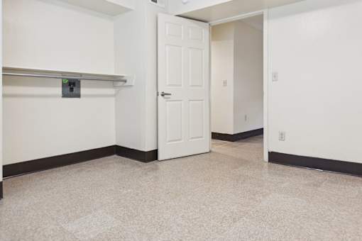 A white door is in a hallway with a tiled floor.