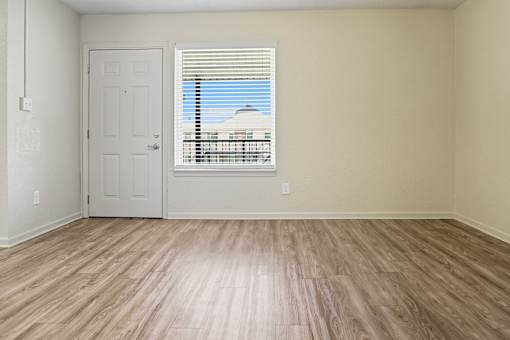 A room with a white door and a window with blinds.