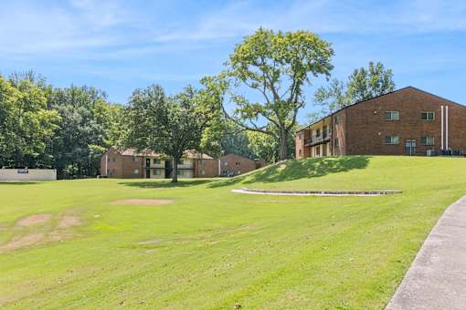 A Grassy Field With a Building in the Background at Hilldale Apartments, Tennessee