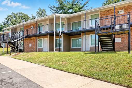 Apartment building with balconies and stairs leading to the second floor.