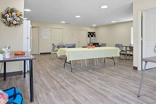 A room with a table and chairs set up for a meeting or event.