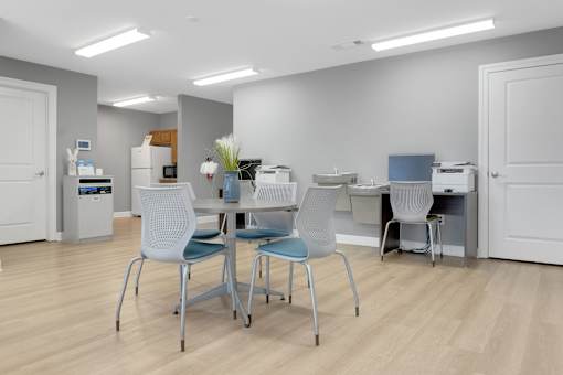 A room with a desk and chairs.
