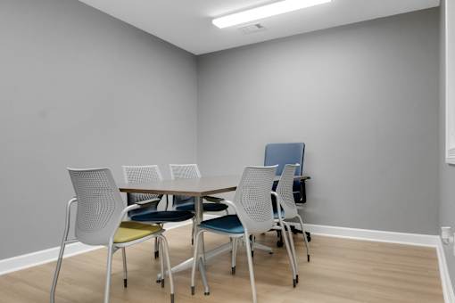 A conference room with a table and chairs.