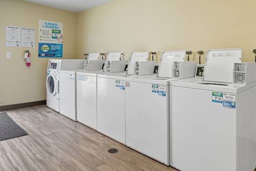 A row of white washing machines in a laundromat.