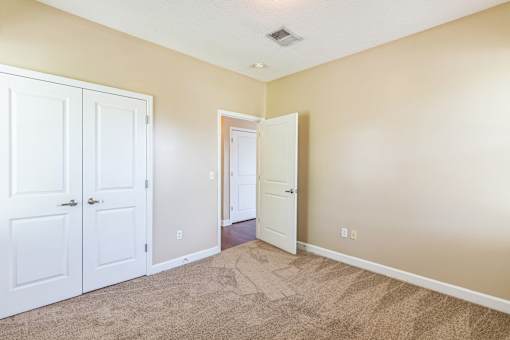 A room with two white doors and a carpeted floor.