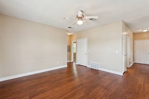 Empty room with wood floors and a ceiling fan.