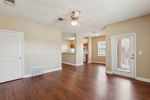 A room with a ceiling fan and hardwood floors.