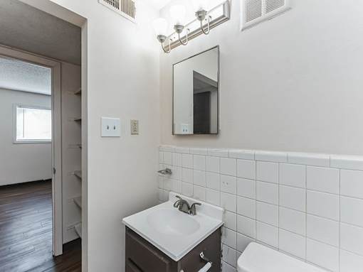 A bathroom with a white sink and a mirror above it.