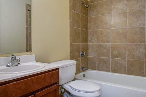 A bathroom with a white toilet, a sink, and a bathtub.
