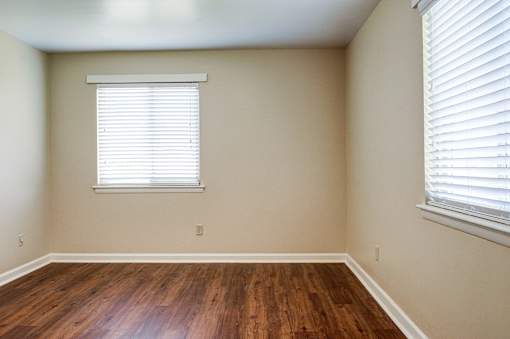 A room with a window and wooden floors.
