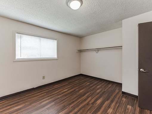 A room with a brown wooden floor and a brown door.