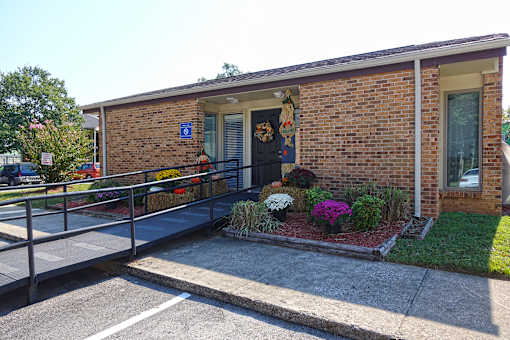 A small brick building with a blue handicap sign on the door.