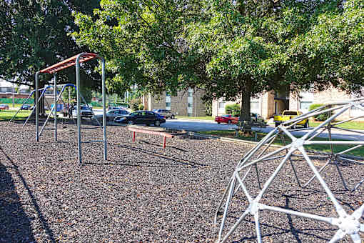 A playground with a swing set and a seesaw.