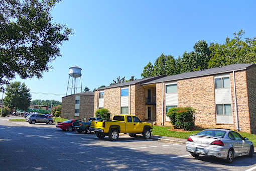 A yellow truck is parked in front of a brick building.