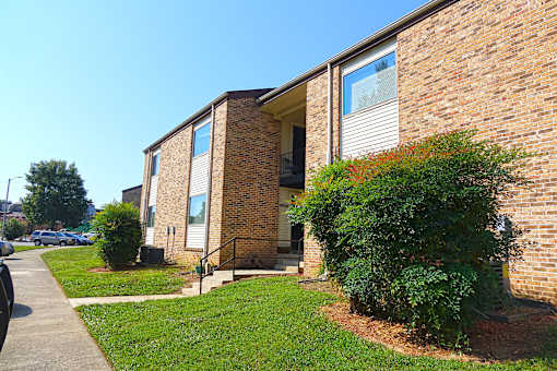 A brick building with a green bush in front.