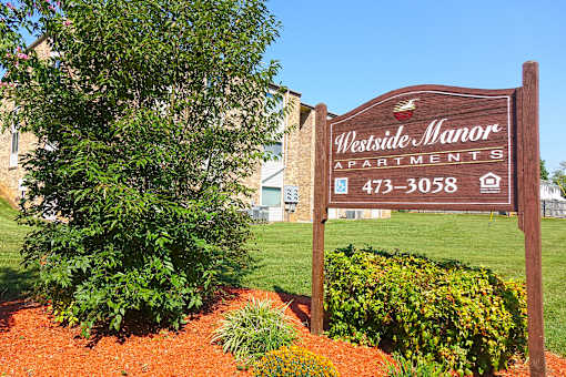 A sign for Westside Manor Apartments is shown in front of a building.
