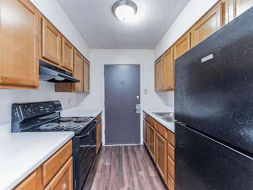 A kitchen with black appliances and wooden cabinets.