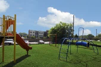 A playground with a yellow slide and a blue slide.