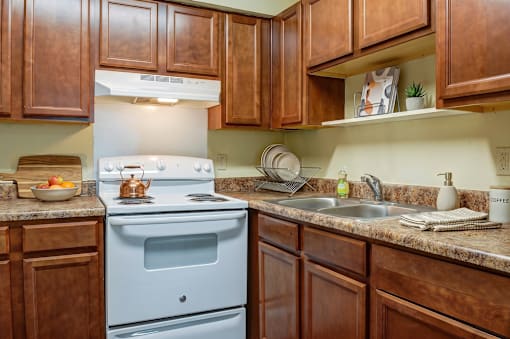 A kitchen with brown cabinets and a white stove.