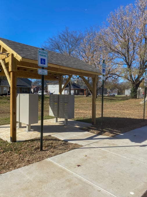 A covered parking area with a sign indicating it is for handicapped parking.