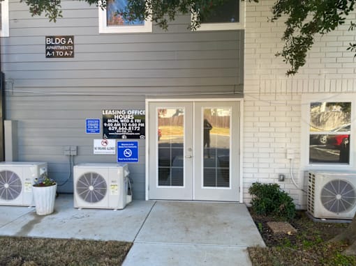 The image shows the front of a building with a sign that reads