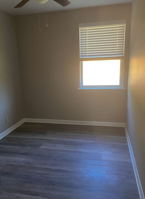 A room with a window and a ceiling fan.