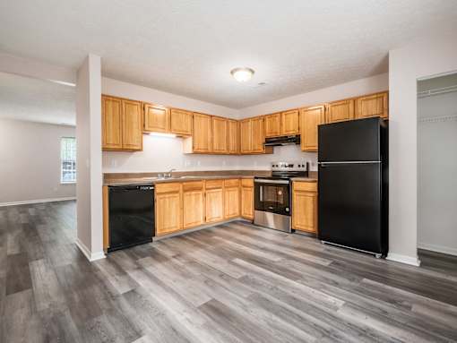 A kitchen with black appliances and wooden cabinets.