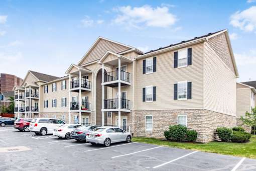 an apartment building with cars parked in a parking lot at Prescott Place, Columbus, OH, 43235