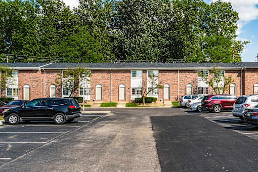 A parking lot with cars and a building in the background.