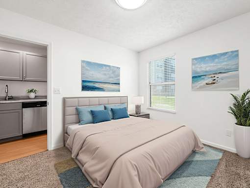 A bedroom with a bed, a sink, and two pictures on the wall.