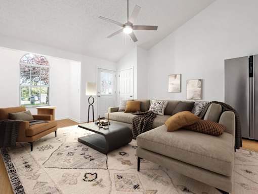 A living room with a couch, a chair, a coffee table, and a rug.