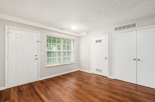 A room with wooden floors and white walls.